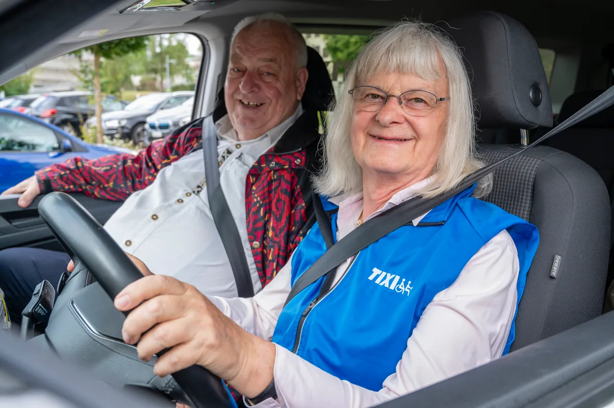 Eine Frau und ein Mann sitzen im Auto.